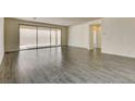 Bright and airy living room featuring wood-look tile floors and a sliding glass door at 907 Gallery Course Dr, Las Vegas, NV 89148