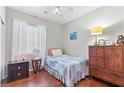 Cozy bedroom features a twin bed, wood floors, ceiling fan, and neutral color scheme for relaxation at 9869 White Lilac St, Las Vegas, NV 89178