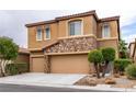Attractive two-story home featuring a stone facade, three-car garage, manicured landscaping, and desert rock accents at 9869 White Lilac St, Las Vegas, NV 89178