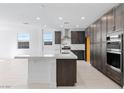 Spacious kitchen showcasing dark wood cabinets, a white center island, and stainless steel appliances at 1005 Warsaw Ave, Henderson, NV 89015