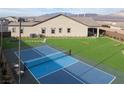 A spacious backyard featuring a full sport court, an artificial lawn, and desert landscaping around the home at 10420 Luella Ct, Las Vegas, NV 89143