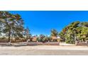 Charming single-story home with well-maintained landscaping and a classic brick fence, perfect for families at 10615 Rancho Destino Rd, Las Vegas, NV 89183