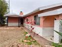 Charming home with desert landscaping, white brick accents, and beautiful flowers in the front yard at 1201 Madison Ave, Las Vegas, NV 89106