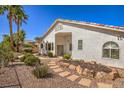 Well-maintained backyard featuring desert landscaping with a rock path and mature trees at 1363 Rolling Sunset St, Henderson, NV 89052