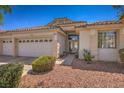Attractive single-story home with a three-car garage, desert landscaping, and a welcoming entrance with double glass doors at 1363 Rolling Sunset St, Henderson, NV 89052