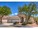Charming single-story home with well-maintained landscaping, a three-car garage and desert landscaping with mature trees at 1363 Rolling Sunset St, Henderson, NV 89052