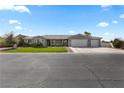 Traditional single-story home featuring a well-manicured lawn and a three-car garage at 1395 Logandale Dr, Logandale, NV 89021