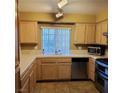 Cozy kitchen featuring wood cabinets, light countertops, and stainless steel appliances, ideal for cooking at 1851 Hillpointe Rd # 2412, Henderson, NV 89074