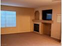 Living room featuring carpeted floors, neutral walls, a fireplace, and a mounted television at 1851 Hillpointe Rd # 2412, Henderson, NV 89074