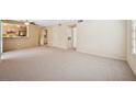 Spacious living room with neutral carpet, ceiling fan and pass through to the kitchen at 1851 Hillpointe Rd # 2412, Henderson, NV 89074