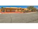 Desert home with a colorful driveway and two-car garage with stone pillar accents at 2201 Rosanna St, Las Vegas, NV 89117