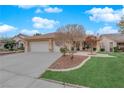 Landscaped single-story home featuring a three-car garage, lawn, and desert landscaping at 2763 Morning Meadow Ct, Las Vegas, NV 89156