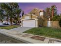 Charming two-story home with a large two car garage, xeriscaping, and a green lawn at 3024 Half Shell Way, Las Vegas, NV 89128
