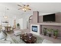 Cozy living room with fireplace, ceiling fan, and a flat screen TV at 3643 Spring Willow Ct, Las Vegas, NV 89147