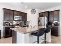 Modern kitchen features dark cabinets, granite counters, a large island, and stainless steel appliances at 369 Monique Springs St, Henderson, NV 89014