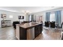 Open floorplan kitchen with granite island, dark cabinets, and stainless steel dishwasher at 369 Monique Springs St, Henderson, NV 89014