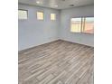 Bedroom with wood-look tile floors, natural lighting, and a vaulted ceiling at 3805 Carisbrook Dr, North Las Vegas, NV 89081