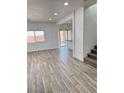Open living space features wood-look tile floors and natural light from a large window at 3805 Carisbrook Dr, North Las Vegas, NV 89081