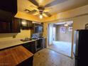 View of the kitchen with dark cabinets, stove, and an outdated kitchen with brown tile flooring at 3967 Visby Ln, Las Vegas, NV 89119