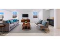 Bright living room with stylish gray furniture, teal accents, and tile flooring at 400 S Jena St, Henderson, NV 89015