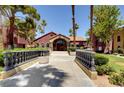 Building entrance surrounded by manicured landscaping, a bridge, and walkways at 4050 Pacific Harbors Dr # 233, Las Vegas, NV 89121