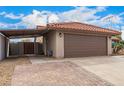Charming single story home featuring a brown two-car garage, a covered carport and desert landscaping at 436 Concord Way, Henderson, NV 89015