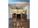 Gourmet kitchen featuring stainless steel appliances, white cabinetry, and hardwood flooring at 4912 Capo Gallo St, Las Vegas, NV 89130