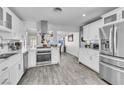 Modern kitchen featuring white cabinets, stainless steel appliances, and wood-look flooring at 5582 Tunis Ave, Las Vegas, NV 89122