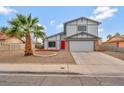 Two-story home featuring desert landscaping, an attached two-car garage, and a red front door at 5815 Christchurch Ave, Las Vegas, NV 89110