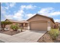Inviting single-story home featuring a two-car garage, desert landscaping, and a spacious driveway at 5991 Saddle Horse Ave, Las Vegas, NV 89122