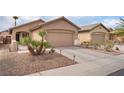 Inviting single-story home featuring a two-car garage, desert landscaping, and a spacious driveway at 5991 Saddle Horse Ave, Las Vegas, NV 89122