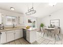 Bright kitchen features white cabinets, stainless steel appliances, and a dining area with pool view at 6155 W Twain Ave, Las Vegas, NV 89103