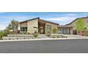 Beautiful home featuring a modern facade, desert landscaping, and a glass garage door at 6690 Interstellar St, Las Vegas, NV 89135