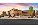 Beautiful home featuring a modern facade, large windows, desert landscaping, and glass garage door at 6690 Interstellar St, Las Vegas, NV 89135
