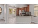 Charming kitchen featuring warm wood cabinetry, granite countertops, and modern stainless steel appliances at 6712 Biltmore Garden St, Las Vegas, NV 89149