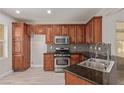 Well-equipped kitchen featuring stainless steel appliances, rich wood cabinets, and mosaic backsplash at 6712 Biltmore Garden St, Las Vegas, NV 89149