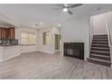 Cozy living area with fireplace, adjacent to an open kitchen and staircase for easy access at 6712 Biltmore Garden St, Las Vegas, NV 89149