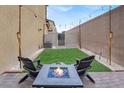 Cozy backyard with artificial turf, decorative lighting, and comfortable seating around a fire pit at 7305 Halo Falls St, North Las Vegas, NV 89084