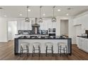 Stylish kitchen featuring white cabinets, black countertops, stainless steel appliances, and an island with seating at 8106 Skye Glen St, Las Vegas, NV 89166