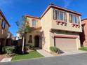 Charming two-story home featuring a stucco facade, arched entry, and an attached two-car garage at 8576 Peaceful Dreams St, Las Vegas, NV 89139