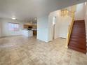 Spacious living room with tile flooring, open to the kitchen and featuring a grand staircase at 8576 Peaceful Dreams St, Las Vegas, NV 89139