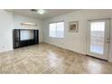 Bright living room with tile flooring and large window, next to door with security bars at 8576 Peaceful Dreams St, Las Vegas, NV 89139