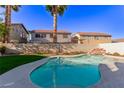 Private backyard pool with a rock waterfall feature provides relaxation in this desert oasis at 9020 Loggers Mill Ave, Las Vegas, NV 89143