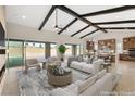 Spacious living room featuring exposed beams, fireplace, and access to the backyard at 9930 Zakos Ct, Las Vegas, NV 89149