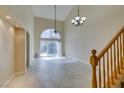 Open-concept living room with tile flooring, high ceiling, and sliding doors to the outside patio at 10311 Birch Bluff Ln, Las Vegas, NV 89145