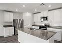 Modern kitchen with stainless steel appliances, gray counters, and ample cabinet space at 1704 Desert Path Ave, North Las Vegas, NV 89032