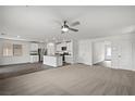 Spacious living room with modern ceiling fan flows into a kitchen with stainless appliances and large island at 1704 Desert Path Ave, North Las Vegas, NV 89032