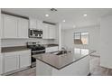 Stylish kitchen with white cabinetry, stainless steel appliances, and a spacious island with a sink at 1717 Desert Path Ave, North Las Vegas, NV 89032