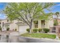 Attractive two-story home featuring a well-maintained lawn, mature tree, and attached two-car garage at 2033 Shining Feather Ln, Las Vegas, NV 89134