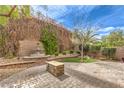 Serene backyard oasis with a stone patio, water fountain, and lush greenery at 2413 Hamonah Dr, Henderson, NV 89044